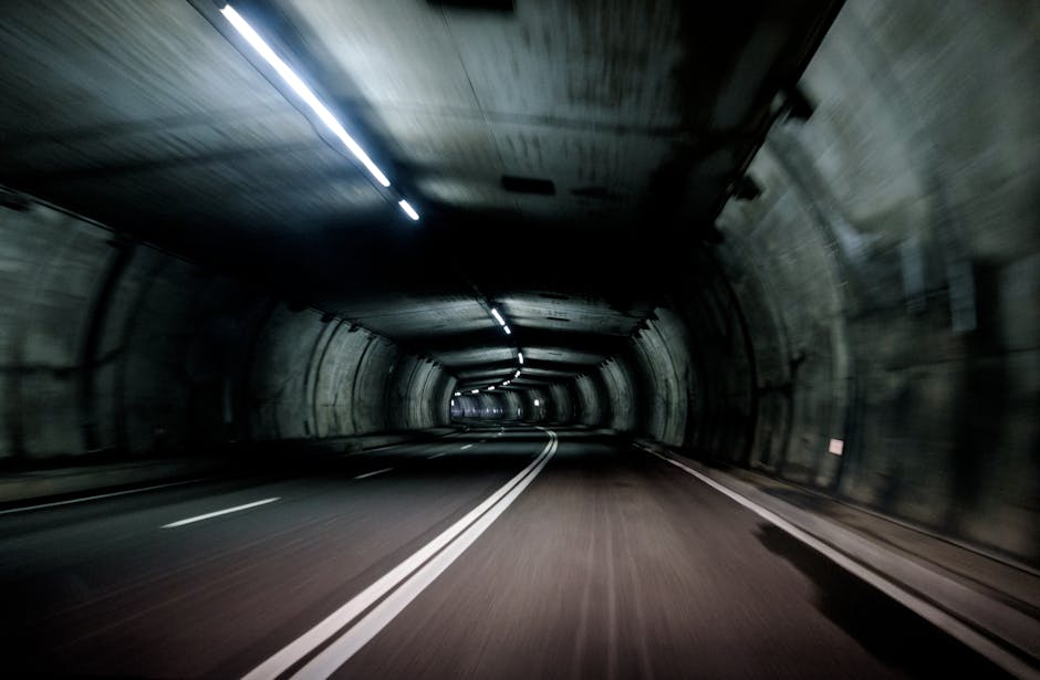 Motion blur of a vehicle traveling through a dimly lit tunnel at high speed.
