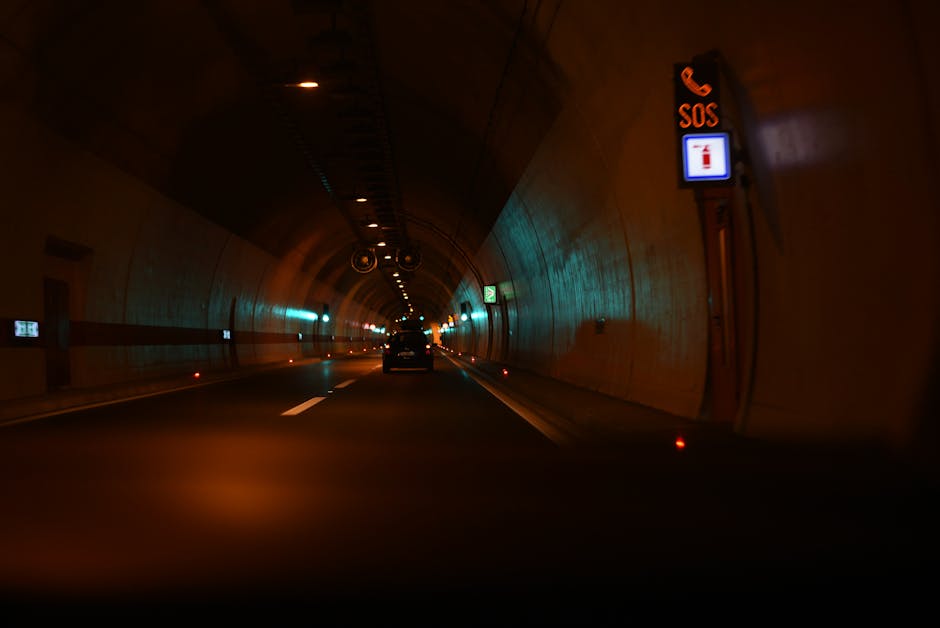 Long exposure of a car drive through an illuminated urban tunnel at night.